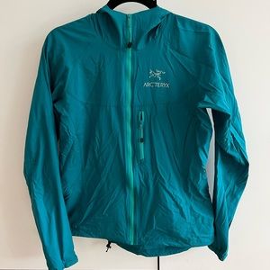 Arc’Teryx teal windbreaker.